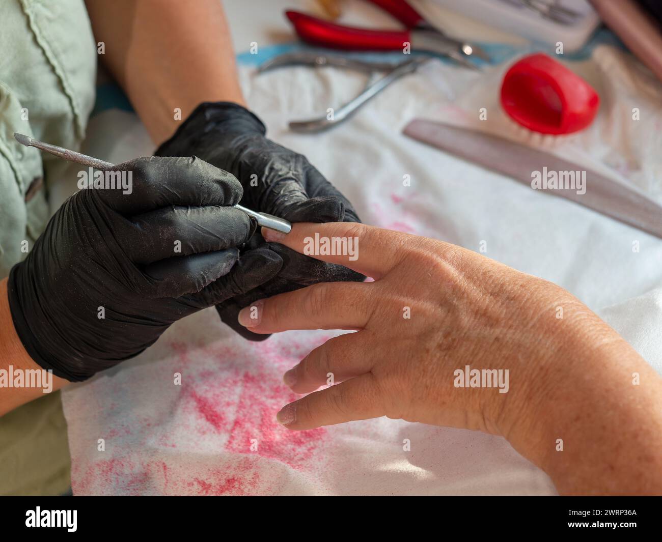 Maniküre-Frau, die Nagelhaut mit einem Nagelentferner für permanente Nagelfarbe entfernt Stockfoto