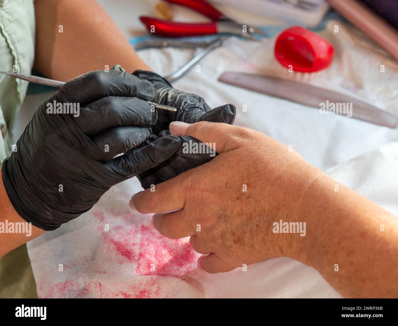 Maniküre-Frau, die Nagelhaut mit einem Nagelentferner für permanente Nagelfarbe entfernt Stockfoto