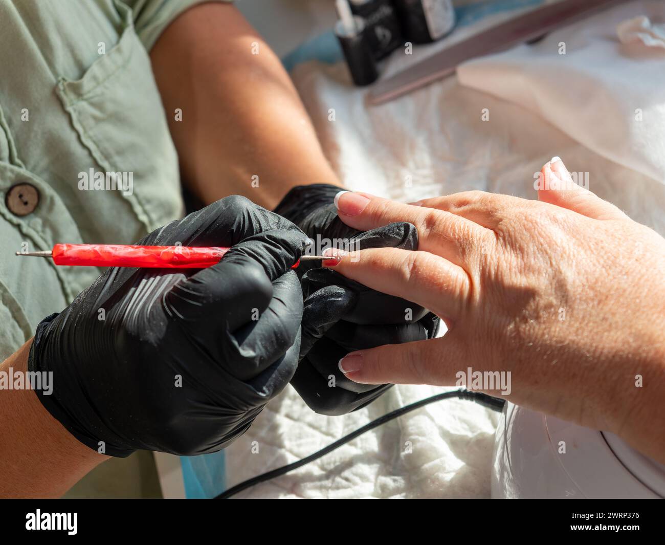 Maniküre mit einem präzisionspolierpinsel eine Blume mit permanentem Nagellack Stockfoto