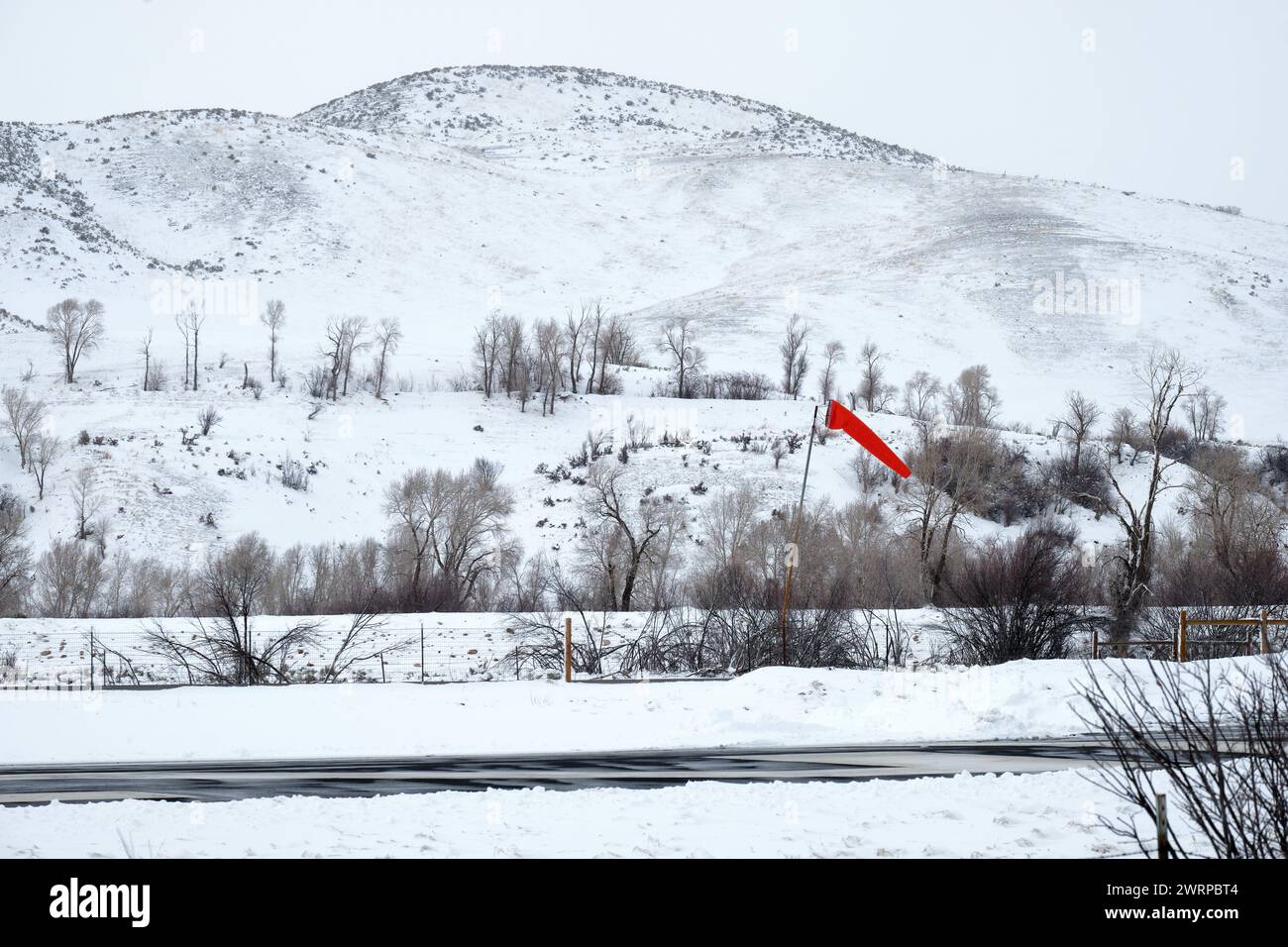 Der Windsock am Morgan County Airport, Mountain Green, Utah, bietet die einzige Farbe an einem winterlichen Tag. Stockfoto
