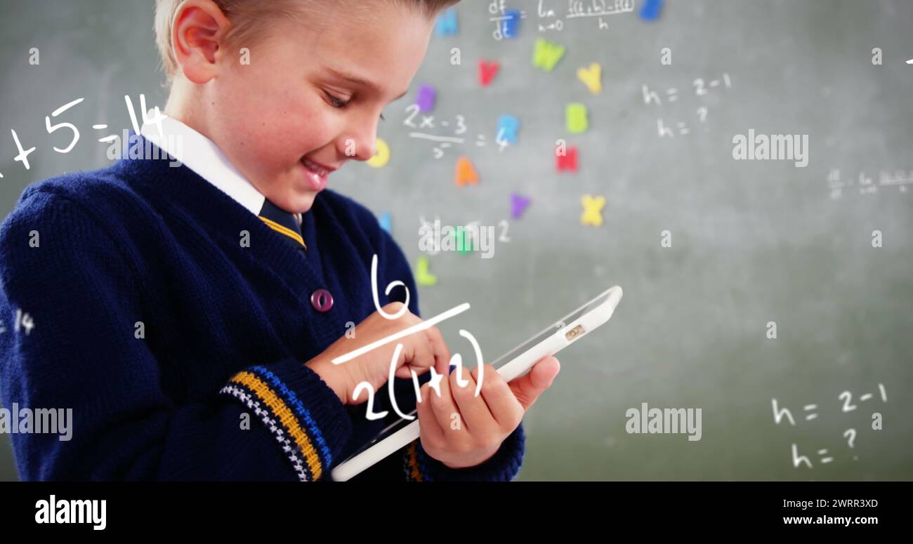 Der lächelnde Schuljunge mit Tablet zeigt digitale Bildung durch mathematische Gleichungen. Stockfoto