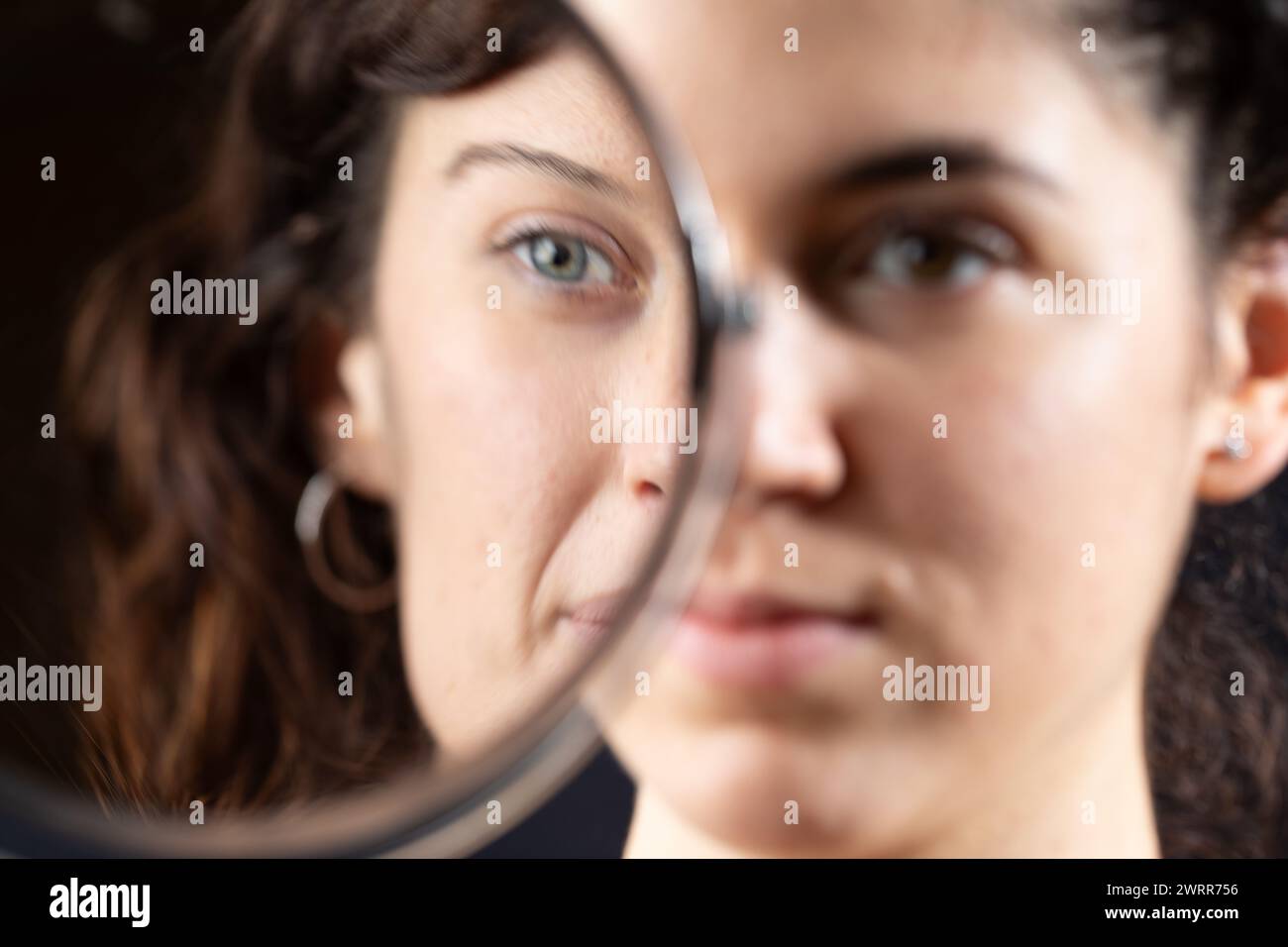 Künstlerische Darstellung des Gesichts einer Frau, halb im Spiegel gesehen Stockfoto