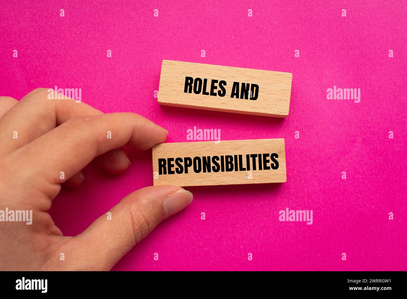 Rollen- und Verantwortungsworte auf Holzblöcken mit rosa Hintergrund. Konzeptsymbol. Kopierbereich. Stockfoto
