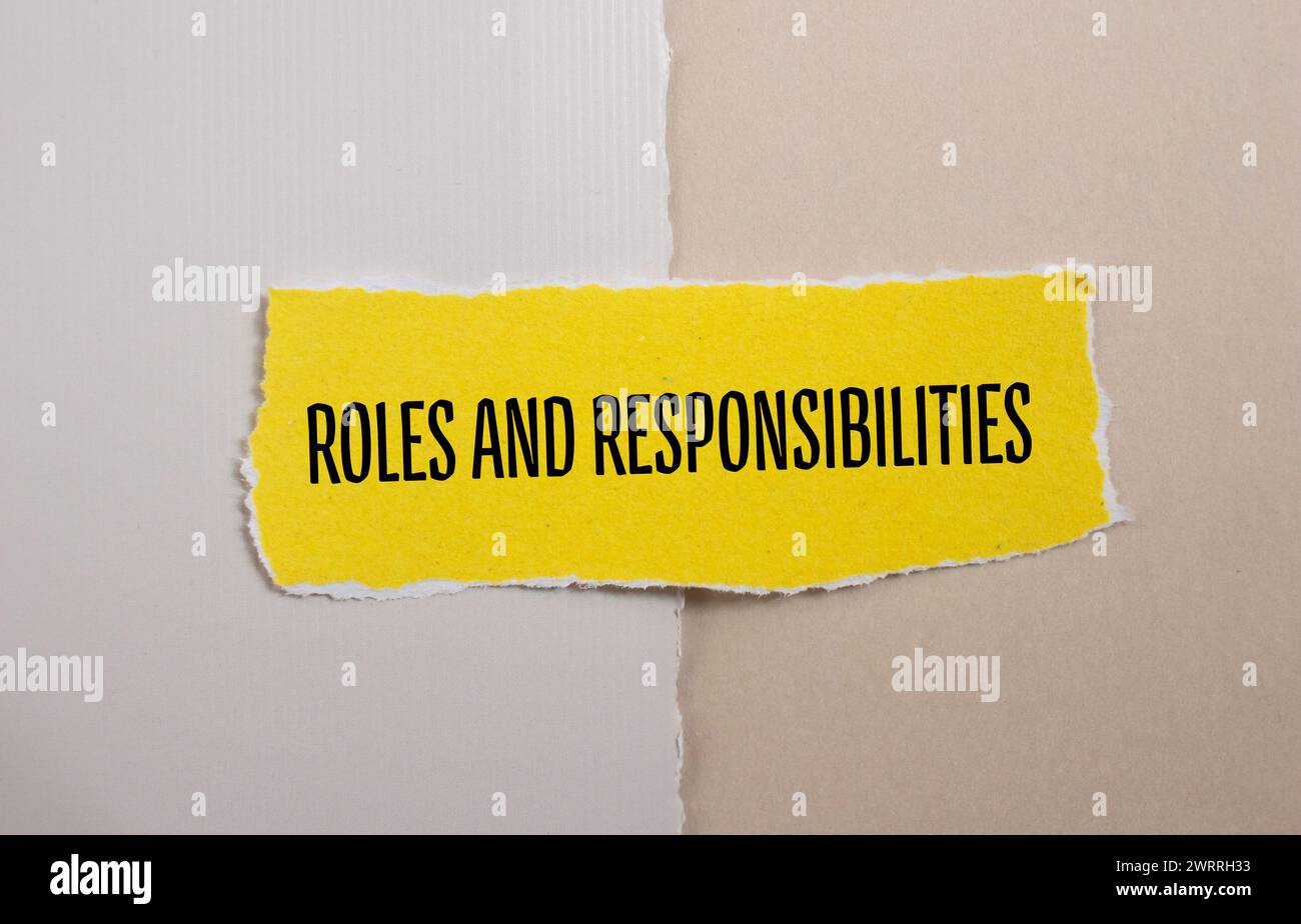 Wörter zu Rollen und Verantwortlichkeiten auf gelbem zerrissenem Papier. Konzeptsymbol. Kopierbereich. Stockfoto