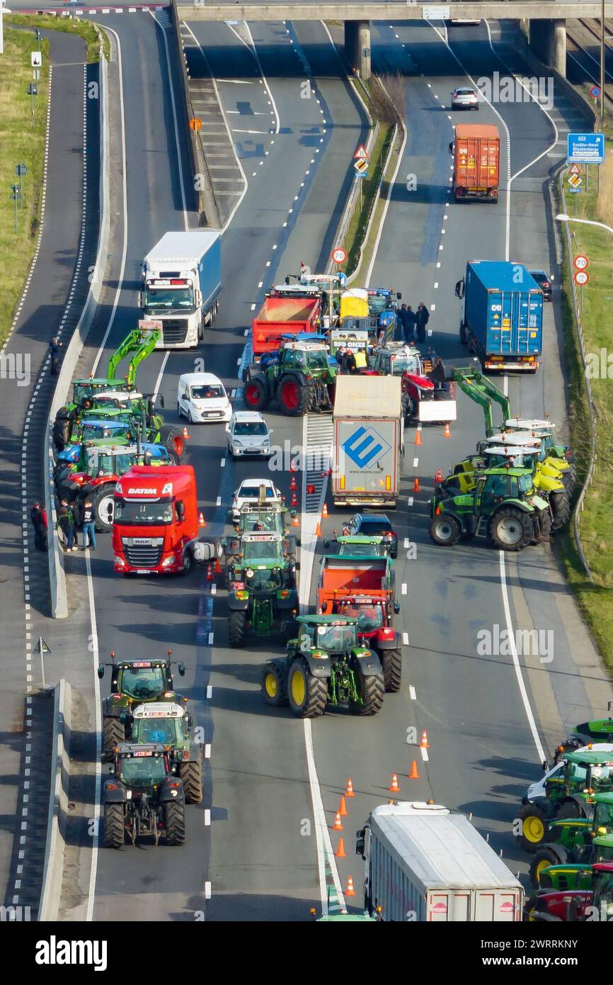 Zeebrugge, Belgien. März 2024. Die Luftaufnahme zeigt Lkw und Traktoren, die während eines Bauernprotests am Donnerstag, den 14. März 2024, den Zugang von LKWs zum Hafen Antwerpen-Brügge in Zeebrugge blockierten. Zwei unabhängige Junglandwirtenverbände protestieren weiterhin gegen die strengen Stickstoffvorschriften für Landwirte. Durch die Sperrung der Häfen wollen die Landwirte darauf hinweisen, dass es vor allem die Industrie ist, die Stickstoff ausstößt, und nicht die Landwirtschaft. BELGA FOTO KURT DESPLENTER Credit: Belga Nachrichtenagentur/Alamy Live News Stockfoto