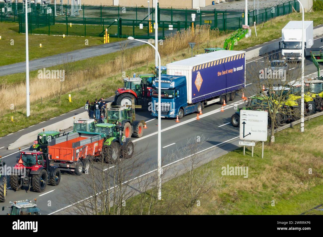 Zeebrugge, Belgien. März 2024. Die Luftaufnahme zeigt Lkw und Traktoren, die während eines Bauernprotests am Donnerstag, den 14. März 2024, den Zugang von LKWs zum Hafen Antwerpen-Brügge in Zeebrugge blockierten. Zwei unabhängige Junglandwirtenverbände protestieren weiterhin gegen die strengen Stickstoffvorschriften für Landwirte. Durch die Sperrung der Häfen wollen die Landwirte darauf hinweisen, dass es vor allem die Industrie ist, die Stickstoff ausstößt, und nicht die Landwirtschaft. BELGA FOTO KURT DESPLENTER Credit: Belga Nachrichtenagentur/Alamy Live News Stockfoto