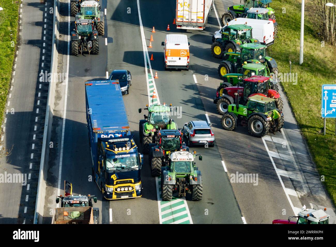 Zeebrugge, Belgien. März 2024. Die Luftaufnahme zeigt Lkw und Traktoren, die während eines Bauernprotests am Donnerstag, den 14. März 2024, den Zugang von LKWs zum Hafen Antwerpen-Brügge in Zeebrugge blockierten. Zwei unabhängige Junglandwirtenverbände protestieren weiterhin gegen die strengen Stickstoffvorschriften für Landwirte. Durch die Sperrung der Häfen wollen die Landwirte darauf hinweisen, dass es vor allem die Industrie ist, die Stickstoff ausstößt, und nicht die Landwirtschaft. BELGA FOTO KURT DESPLENTER Credit: Belga Nachrichtenagentur/Alamy Live News Stockfoto