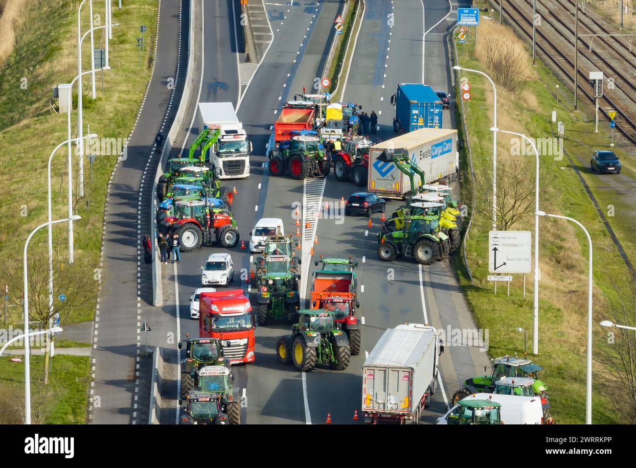 Zeebrugge, Belgien. März 2024. Die Luftaufnahme zeigt Lkw und Traktoren, die während eines Bauernprotests am Donnerstag, den 14. März 2024, den Zugang von LKWs zum Hafen Antwerpen-Brügge in Zeebrugge blockierten. Zwei unabhängige Junglandwirtenverbände protestieren weiterhin gegen die strengen Stickstoffvorschriften für Landwirte. Durch die Sperrung der Häfen wollen die Landwirte darauf hinweisen, dass es vor allem die Industrie ist, die Stickstoff ausstößt, und nicht die Landwirtschaft. BELGA FOTO KURT DESPLENTER Credit: Belga Nachrichtenagentur/Alamy Live News Stockfoto
