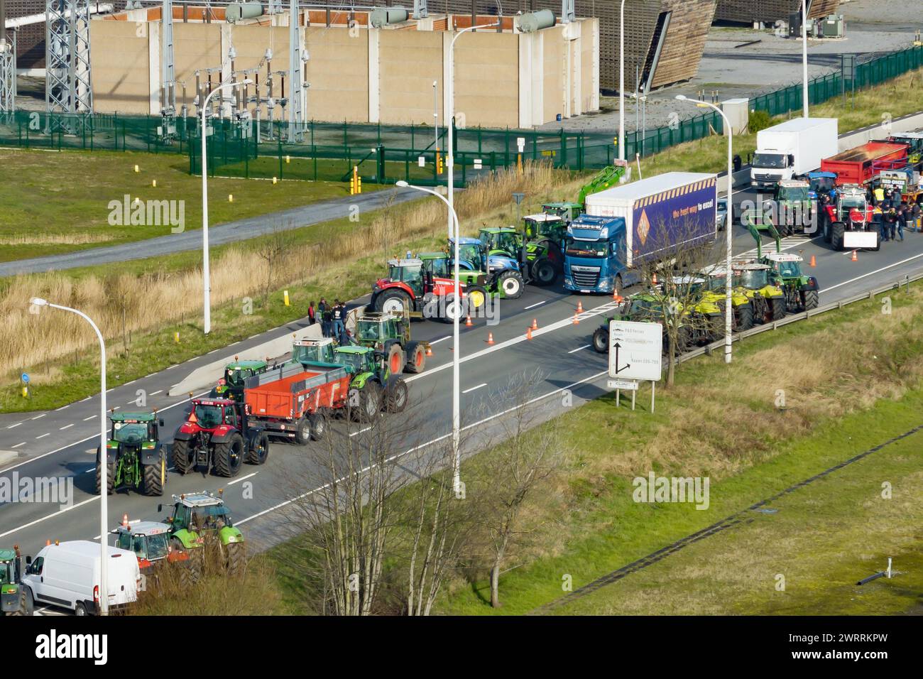 Zeebrugge, Belgien. März 2024. Die Luftaufnahme zeigt Lkw und Traktoren, die während eines Bauernprotests am Donnerstag, den 14. März 2024, den Zugang von LKWs zum Hafen Antwerpen-Brügge in Zeebrugge blockierten. Zwei unabhängige Junglandwirtenverbände protestieren weiterhin gegen die strengen Stickstoffvorschriften für Landwirte. Durch die Sperrung der Häfen wollen die Landwirte darauf hinweisen, dass es vor allem die Industrie ist, die Stickstoff ausstößt, und nicht die Landwirtschaft. BELGA FOTO KURT DESPLENTER Credit: Belga Nachrichtenagentur/Alamy Live News Stockfoto