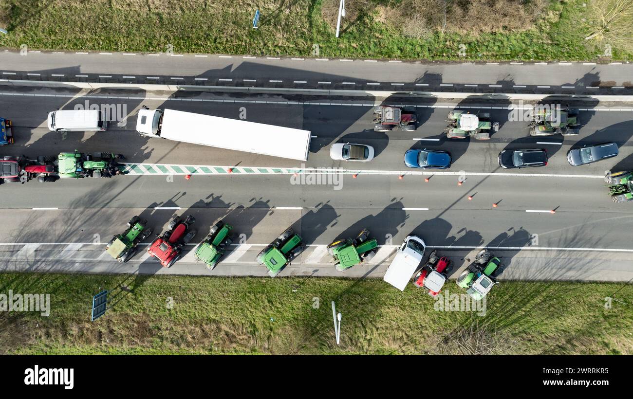 Zeebrugge, Belgien. März 2024. Die Luftaufnahme zeigt Lkw und Traktoren, die während eines Bauernprotests am Donnerstag, den 14. März 2024, den Zugang von LKWs zum Hafen Antwerpen-Brügge in Zeebrugge blockierten. Zwei unabhängige Junglandwirtenverbände protestieren weiterhin gegen die strengen Stickstoffvorschriften für Landwirte. Durch die Sperrung der Häfen wollen die Landwirte darauf hinweisen, dass es vor allem die Industrie ist, die Stickstoff ausstößt, und nicht die Landwirtschaft. BELGA FOTO KURT DESPLENTER Credit: Belga Nachrichtenagentur/Alamy Live News Stockfoto