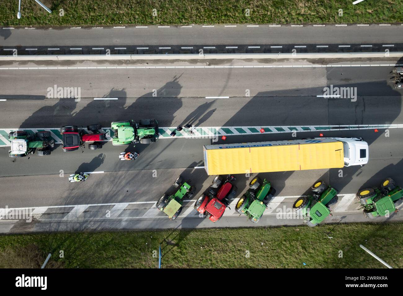 Zeebrugge, Belgien. März 2024. Die Luftaufnahme zeigt Lkw und Traktoren, die während eines Bauernprotests am Donnerstag, den 14. März 2024, den Zugang von LKWs zum Hafen Antwerpen-Brügge in Zeebrugge blockierten. Zwei unabhängige Junglandwirtenverbände protestieren weiterhin gegen die strengen Stickstoffvorschriften für Landwirte. Durch die Sperrung der Häfen wollen die Landwirte darauf hinweisen, dass es vor allem die Industrie ist, die Stickstoff ausstößt, und nicht die Landwirtschaft. BELGA FOTO KURT DESPLENTER Credit: Belga Nachrichtenagentur/Alamy Live News Stockfoto