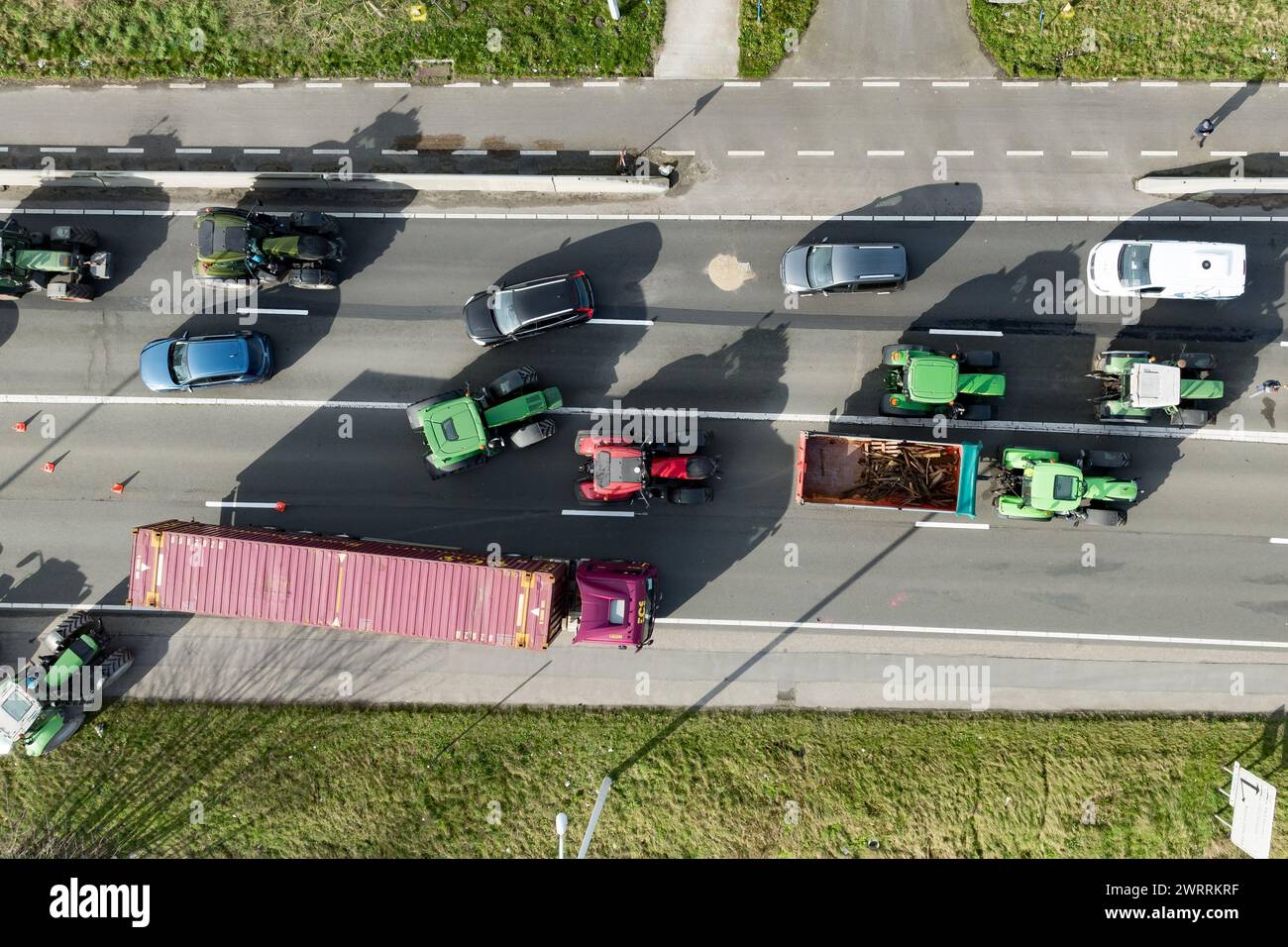 Zeebrugge, Belgien. März 2024. Die Luftaufnahme zeigt Lkw und Traktoren, die während eines Bauernprotests am Donnerstag, den 14. März 2024, den Zugang von LKWs zum Hafen Antwerpen-Brügge in Zeebrugge blockierten. Zwei unabhängige Junglandwirtenverbände protestieren weiterhin gegen die strengen Stickstoffvorschriften für Landwirte. Durch die Sperrung der Häfen wollen die Landwirte darauf hinweisen, dass es vor allem die Industrie ist, die Stickstoff ausstößt, und nicht die Landwirtschaft. BELGA FOTO KURT DESPLENTER Credit: Belga Nachrichtenagentur/Alamy Live News Stockfoto