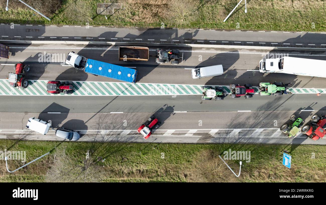 Zeebrugge, Belgien. März 2024. Die Luftaufnahme zeigt Lkw und Traktoren, die während eines Bauernprotests am Donnerstag, den 14. März 2024, den Zugang von LKWs zum Hafen Antwerpen-Brügge in Zeebrugge blockierten. Zwei unabhängige Junglandwirtenverbände protestieren weiterhin gegen die strengen Stickstoffvorschriften für Landwirte. Durch die Sperrung der Häfen wollen die Landwirte darauf hinweisen, dass es vor allem die Industrie ist, die Stickstoff ausstößt, und nicht die Landwirtschaft. BELGA FOTO KURT DESPLENTER Credit: Belga Nachrichtenagentur/Alamy Live News Stockfoto