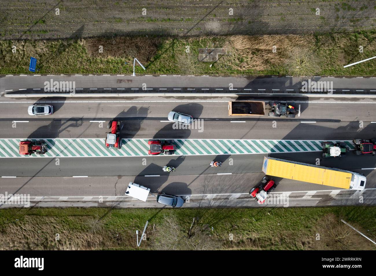 Zeebrugge, Belgien. März 2024. Die Luftaufnahme zeigt Lkw und Traktoren, die während eines Bauernprotests am Donnerstag, den 14. März 2024, den Zugang von LKWs zum Hafen Antwerpen-Brügge in Zeebrugge blockierten. Zwei unabhängige Junglandwirtenverbände protestieren weiterhin gegen die strengen Stickstoffvorschriften für Landwirte. Durch die Sperrung der Häfen wollen die Landwirte darauf hinweisen, dass es vor allem die Industrie ist, die Stickstoff ausstößt, und nicht die Landwirtschaft. BELGA FOTO KURT DESPLENTER Credit: Belga Nachrichtenagentur/Alamy Live News Stockfoto