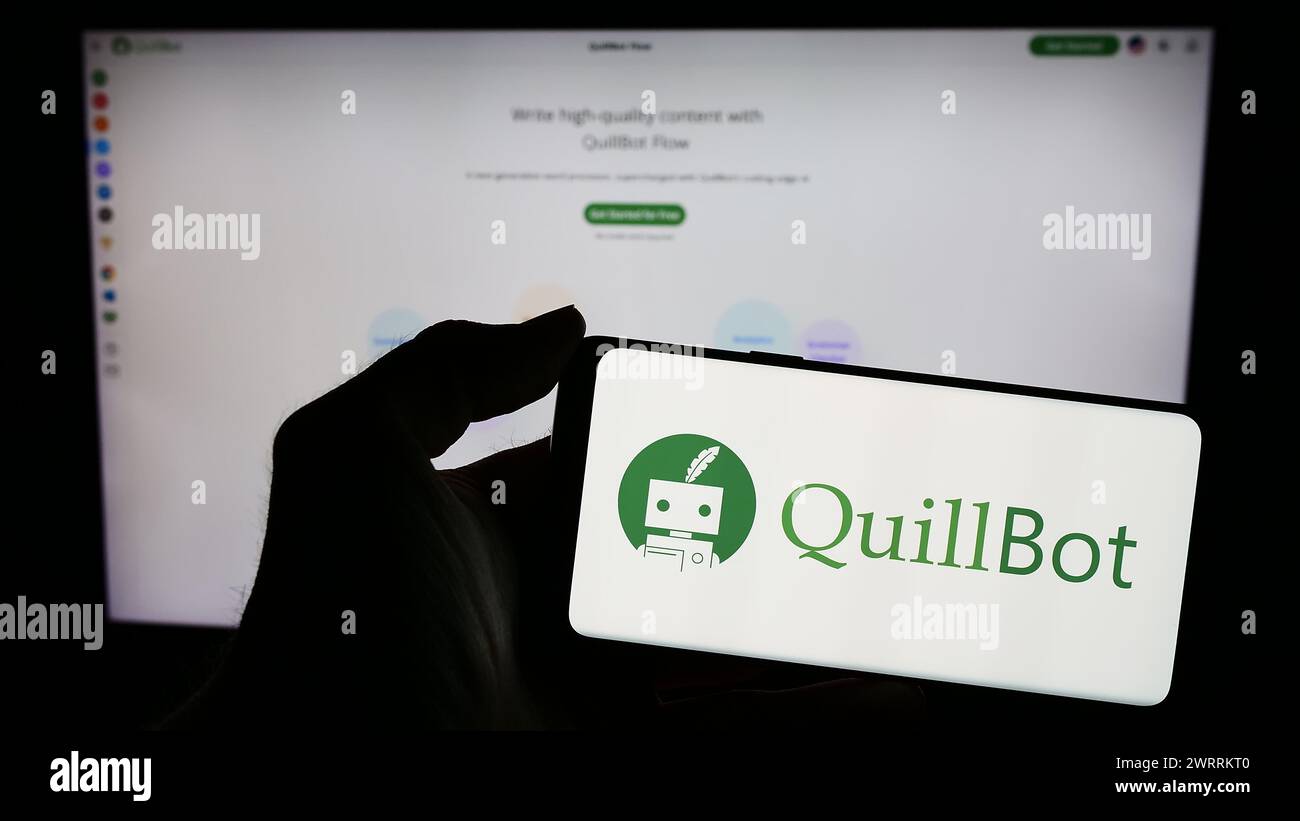 Person, die ein mobiles Pohon mit dem Logo der amerikanischen Schreibfirma QuillBot vor der Webseite hält. Schwerpunkt auf dem Display des Telefons. Stockfoto