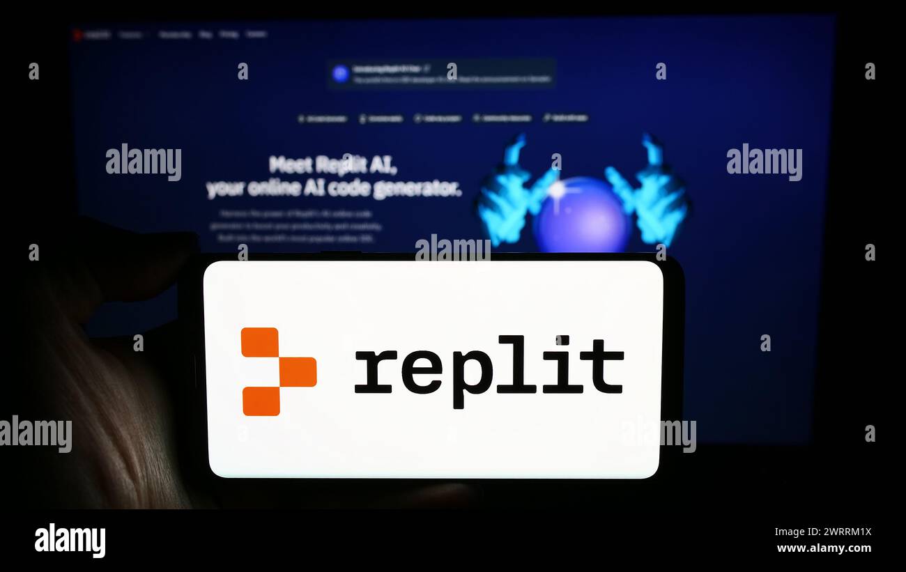 Person, die ein Mobiltelefon mit dem Logo des US-amerikanischen Softwareentwicklungsplattform Replit Inc. Vor der Unternehmenswebseite hält. Schwerpunkt auf dem Display des Telefons. Stockfoto