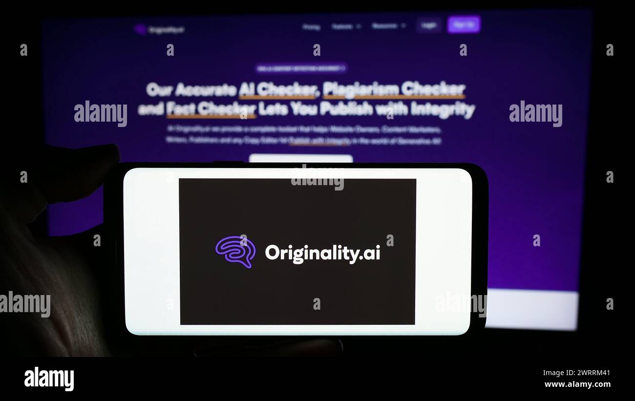 Person, die ein Handy mit dem Logo der kanadischen Plagiatchecker-Firma Originality.AI Inc. Vor der Webseite hält. Schwerpunkt auf dem Display des Telefons. Stockfoto