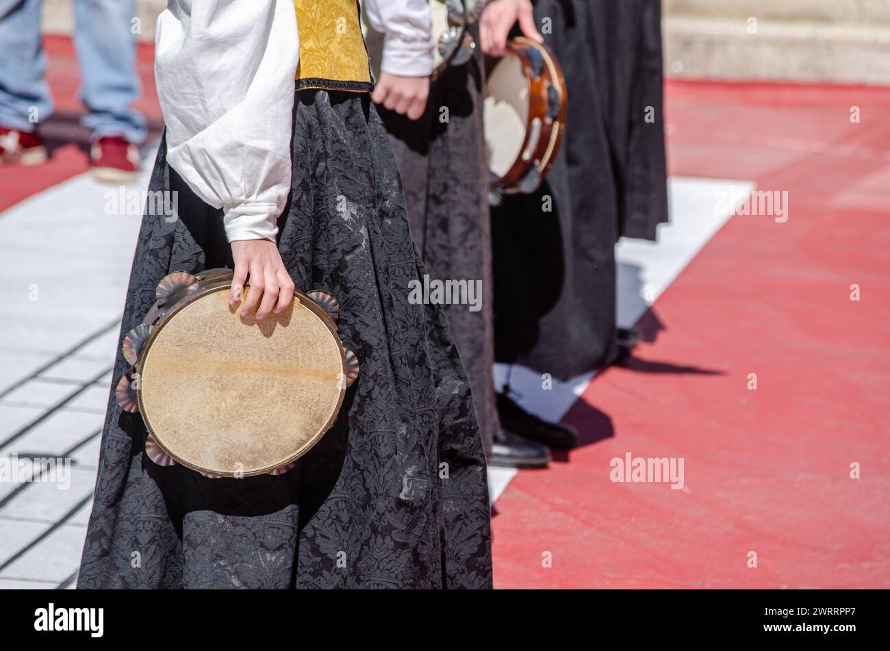 Teilbetrachtung der Frauen bei einer Musikveranstaltung mit traditioneller galizischer Tracht und Tamburinen Stockfoto