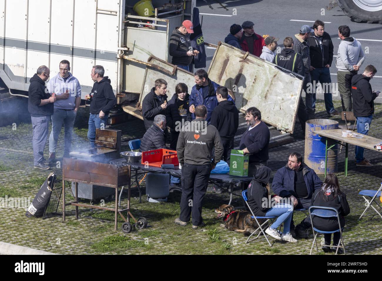 Gent, Belgien. März 2024. Die Bauern haben es sich mit einem Grill, Gartenstühlen und einem Tisch gemütlich gemacht, während der Bauernprotest am Donnerstag, den 14. März 2024, den Einlass von LKWs zum Hafen von Gent blockierte. Zwei unabhängige Junglandwirte-Verbände protestieren weiterhin gegen die strengen Stickstoffvorschriften für Landwirte. Durch die Sperrung der Häfen wollen die Landwirte darauf hinweisen, dass es vor allem die Industrie ist, die Stickstoff ausstößt, und nicht die Landwirtschaft. BELGA FOTO NICOLAS MAETERLINCK Credit: Belga News Agency/Alamy Live News Stockfoto