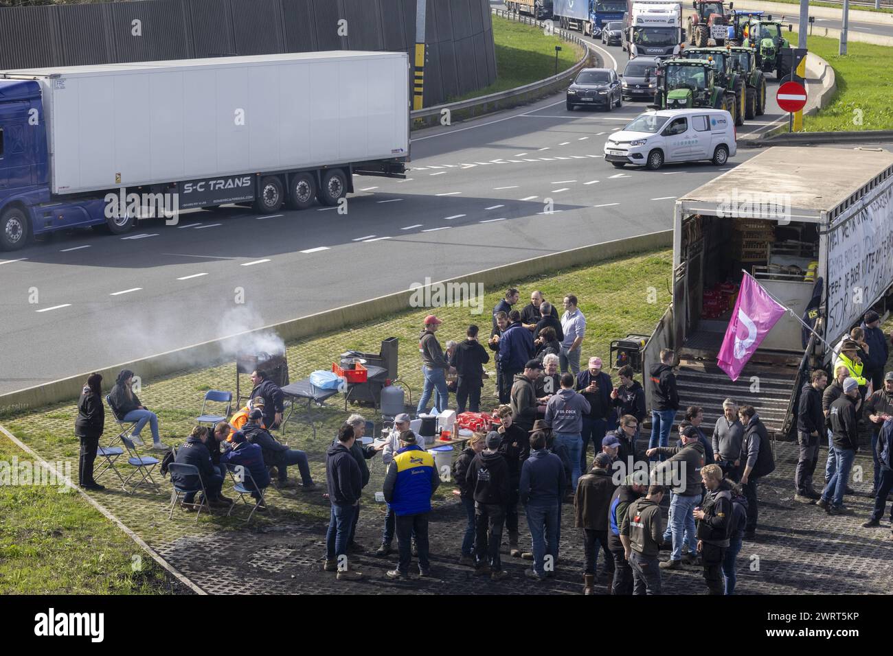 Gent, Belgien. März 2024. Die Bauern haben es sich mit einem Grill, Gartenstühlen und einem Tisch gemütlich gemacht, während der Bauernprotest am Donnerstag, den 14. März 2024, den Einlass von LKWs zum Hafen von Gent blockierte. Zwei unabhängige Junglandwirte-Verbände protestieren weiterhin gegen die strengen Stickstoffvorschriften für Landwirte. Durch die Sperrung der Häfen wollen die Landwirte darauf hinweisen, dass es vor allem die Industrie ist, die Stickstoff ausstößt, und nicht die Landwirtschaft. BELGA FOTO NICOLAS MAETERLINCK Credit: Belga News Agency/Alamy Live News Stockfoto