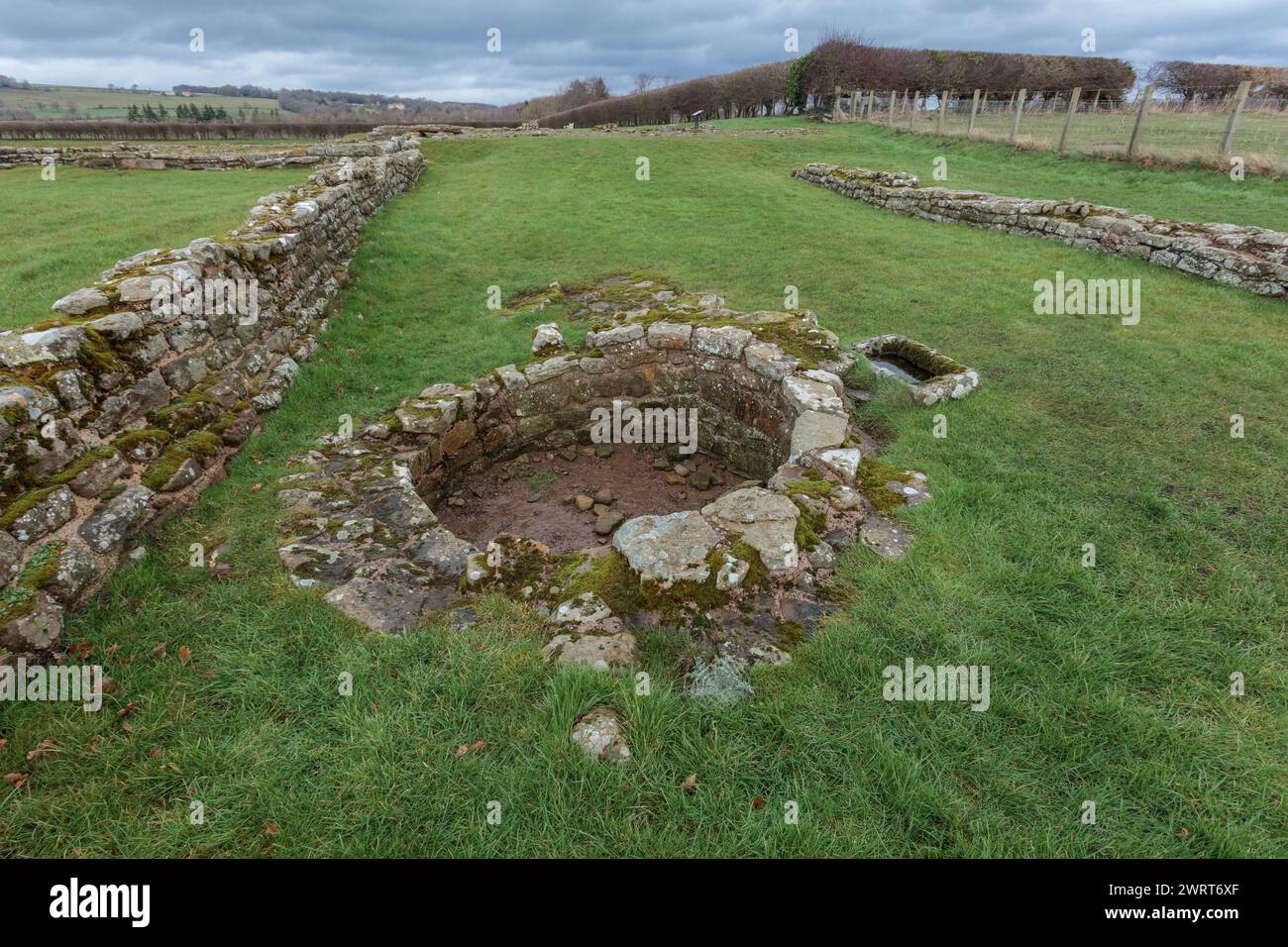 Corbridge Roman Town, Northumberland, England, Großbritannien: Ursprünglich Coria. Ein römisches Fort & Garrison südlich der Hadriansmauer. Überreste eines Brunnens Stockfoto