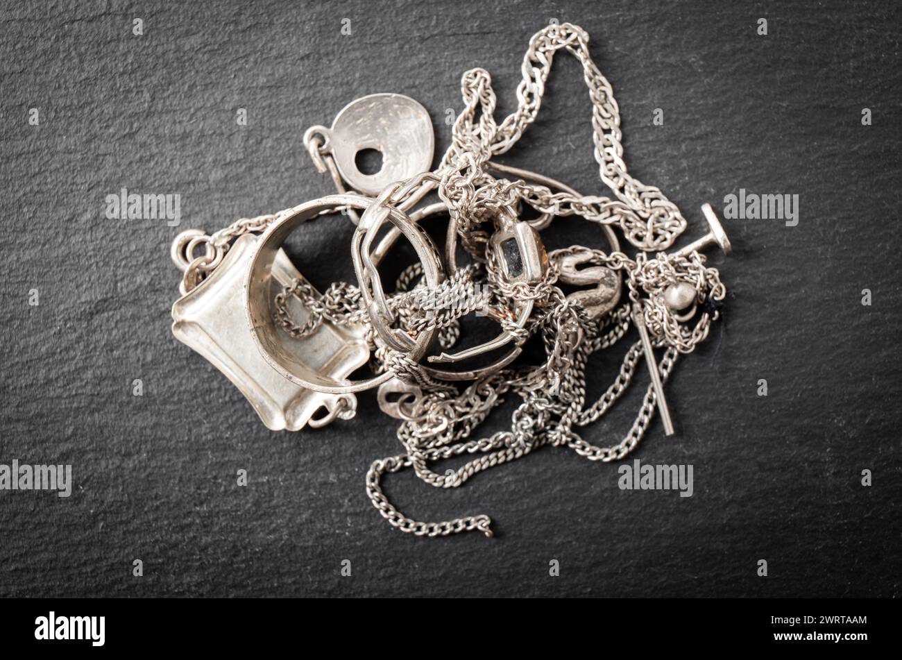Ein Haufen alter Silberschrott, Ringe, Anhänger, Ketten, Ohrringe. Recycling-Konzept für Silberobjekte. Stockfoto