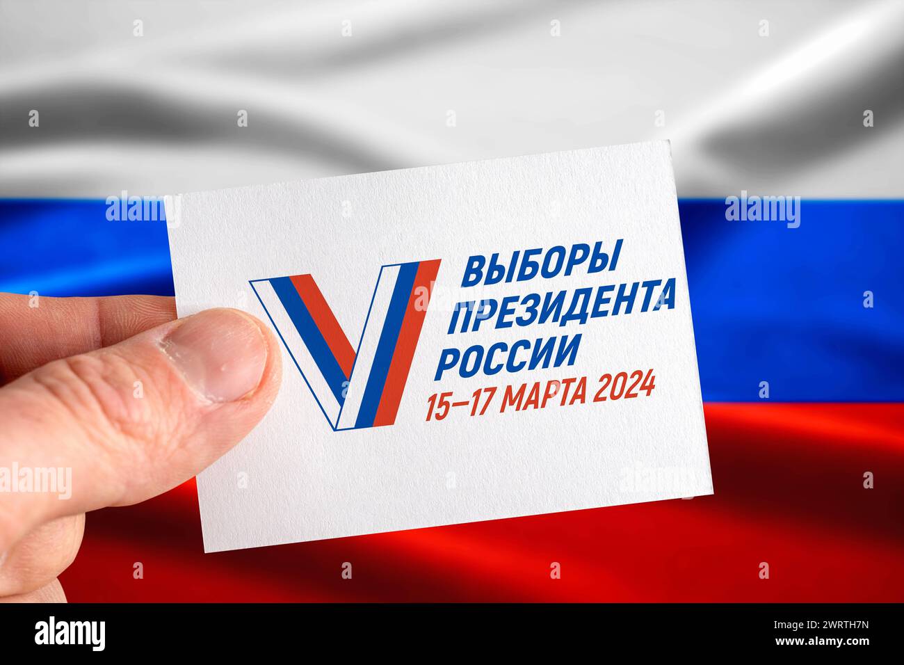 14. März 2024: Symbolisches Bild der Präsidentschaftswahlen 2024 in Russland vom 15. Bis 17. März. Hand mit Stimmkarte vor der russischen Flagge. FOTO *** Symbolbild Präsidentschaftswahl 2024 in Russland vom 15. Bis 17. März. Hand mit Stimmkarte vor russischer Flagge. FOTOMONTAGE Stockfoto