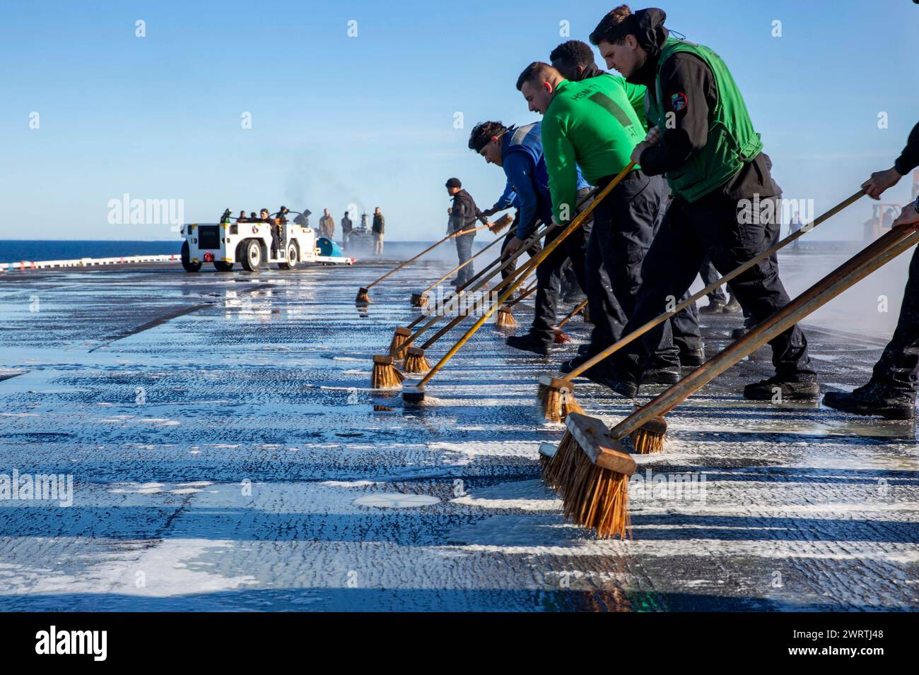 240215-N-DF558-1042 PAZIFISCHER OZEAN (15. Februar 2024) Seeleute schrubben das Flugdeck des Flugzeugträgers USS Abraham Lincoln (CVN 72) der Nimitz-Klasse Stockfoto