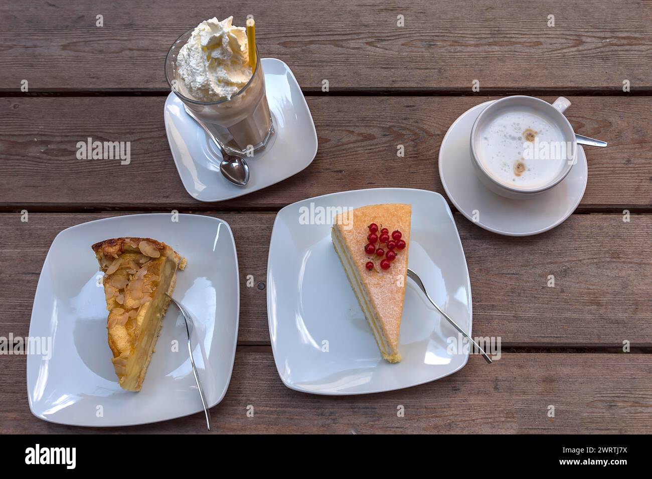 Kuchen und Eiskaffee mit Creme und Cappuccino auf einem Holztisch, Mecklenburg-Vorpommern, Deutschland Stockfoto