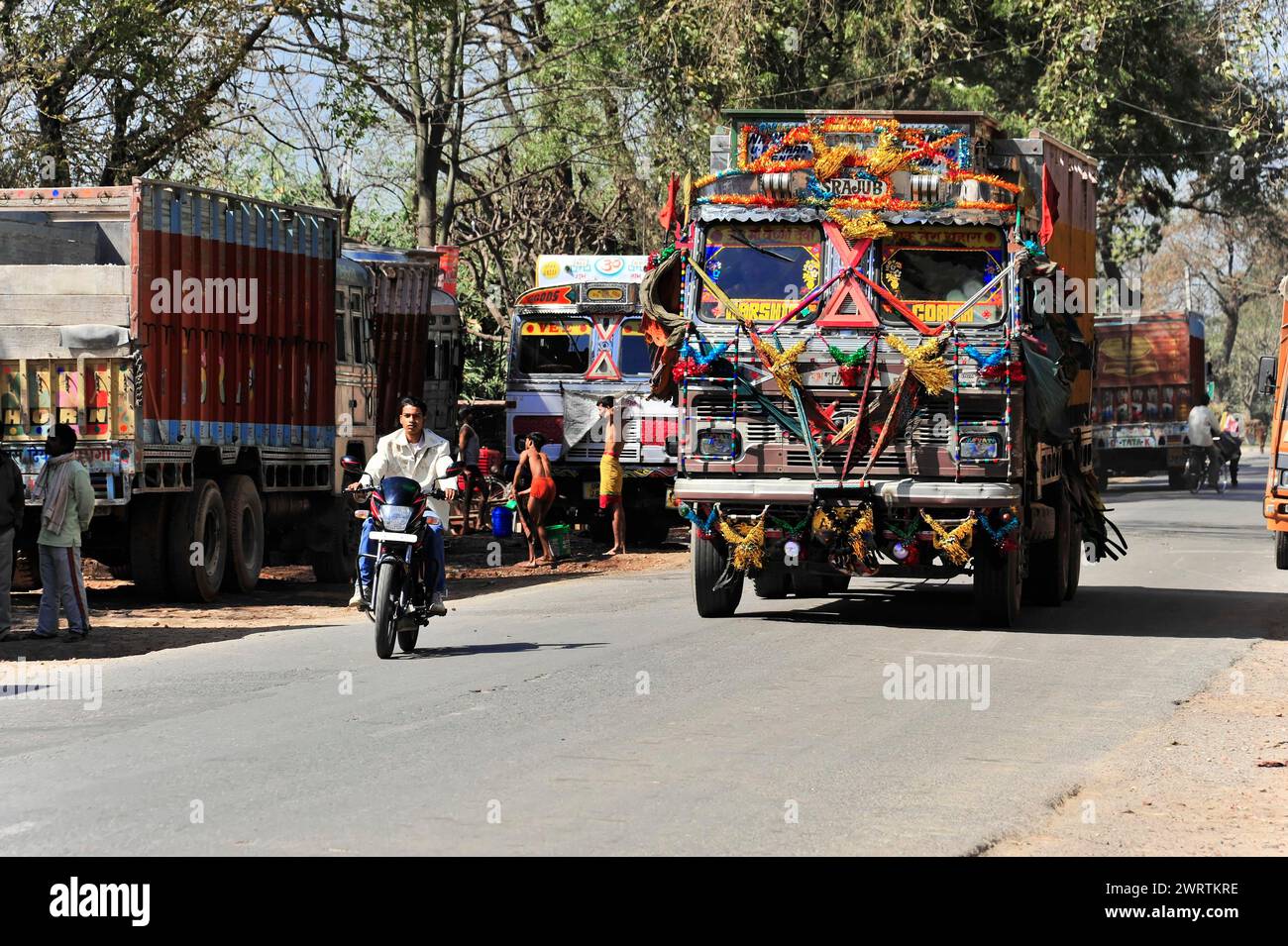 Ein schwer beladener und reich dekorierter LKW fährt auf einer befahrenen Straße neben anderen Fahrzeugen und Menschen, die Grenze zwischen Indien und Nepal, Gorakhpur, Bhairahawa Stockfoto