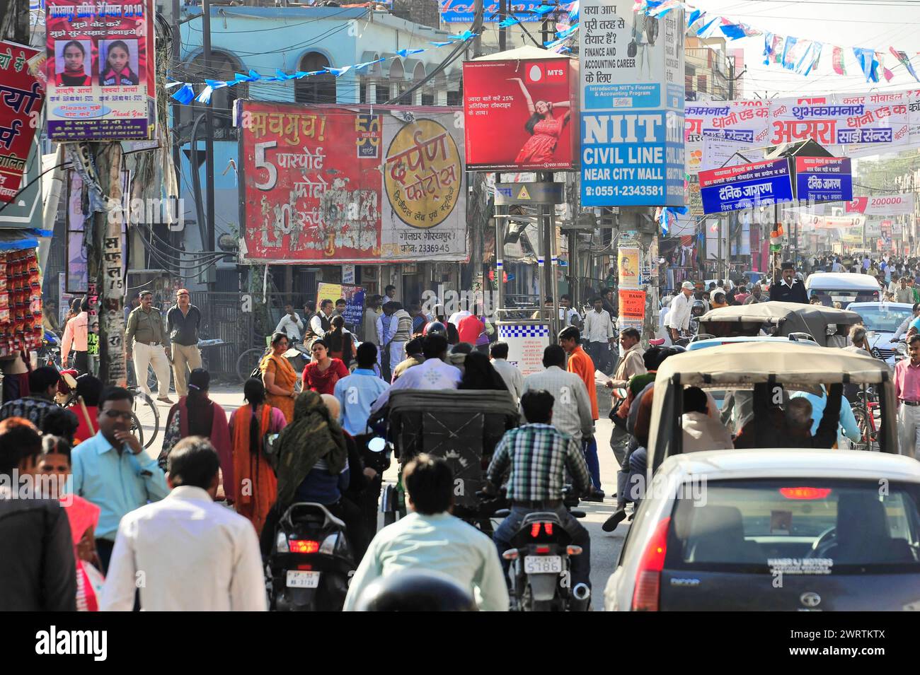 Geschäftige Straße mit Menschen, Geschäften und zahlreichen Werbeschildern, Grenze zwischen Indien und Nepal, Gorakhpur, Bhairahawa, Indien, Nepal Stockfoto