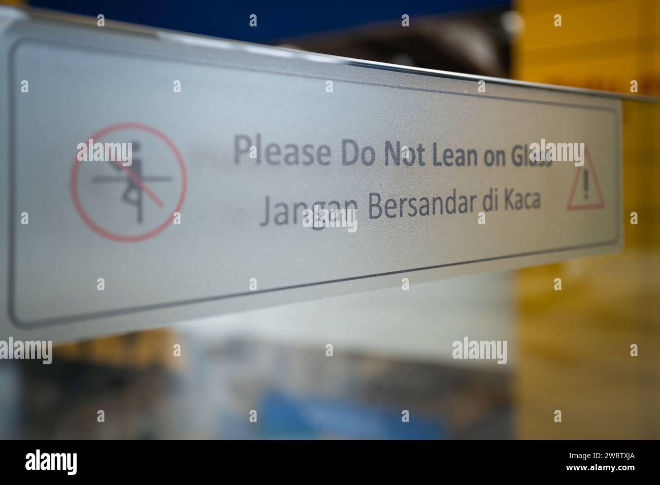 Aufkleber „Bitte nicht auf Glas legen“ auf dem Glasgeländer. Stockfoto