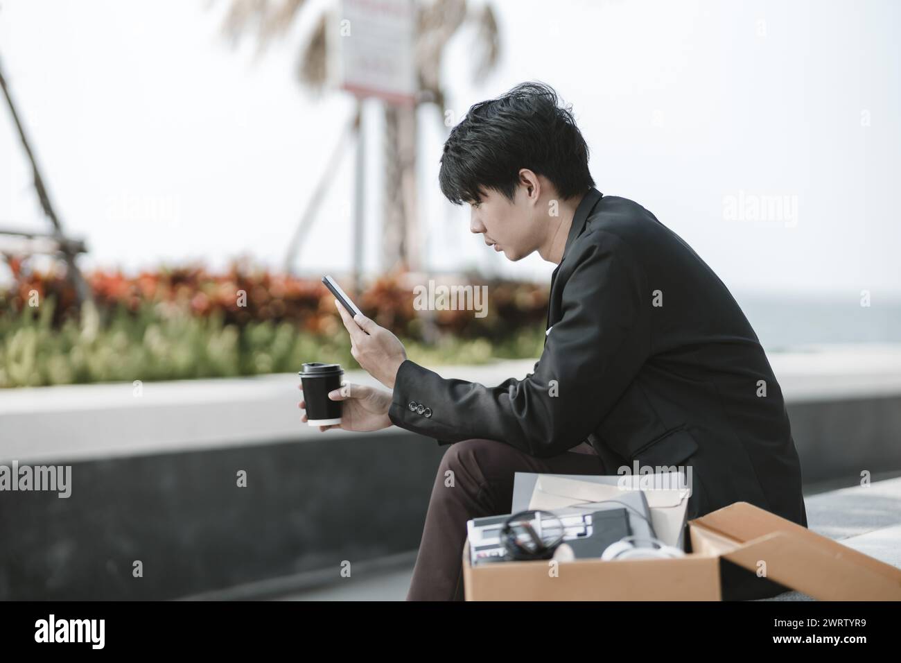 Mitarbeiter, die aus dem Unternehmen entlassen wurden oder aus dem Unternehmen entlassen wurden, nutzen ihr Mobiltelefon, um nach Stellen zu suchen. Arbeitslos, Einstellung, Kündigung des Arbeitsplatzes Konzept. Stockfoto