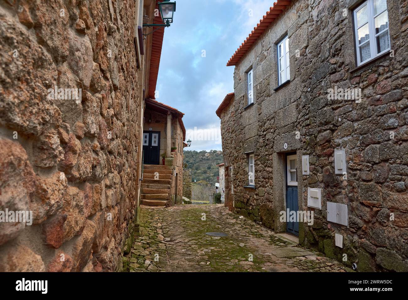 Ein malerischer Blick auf zwei enge Steinstraßen in einem alten europäischen Dorf mit Treppen, die zu einer Tür führen Stockfoto