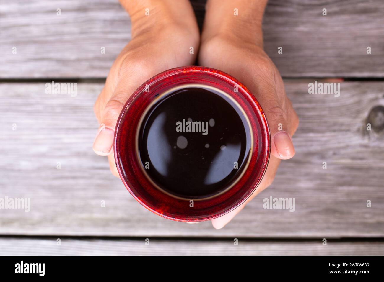 kaukasische Frau, die eine Tasse Kaffee von oben hält Stockfoto