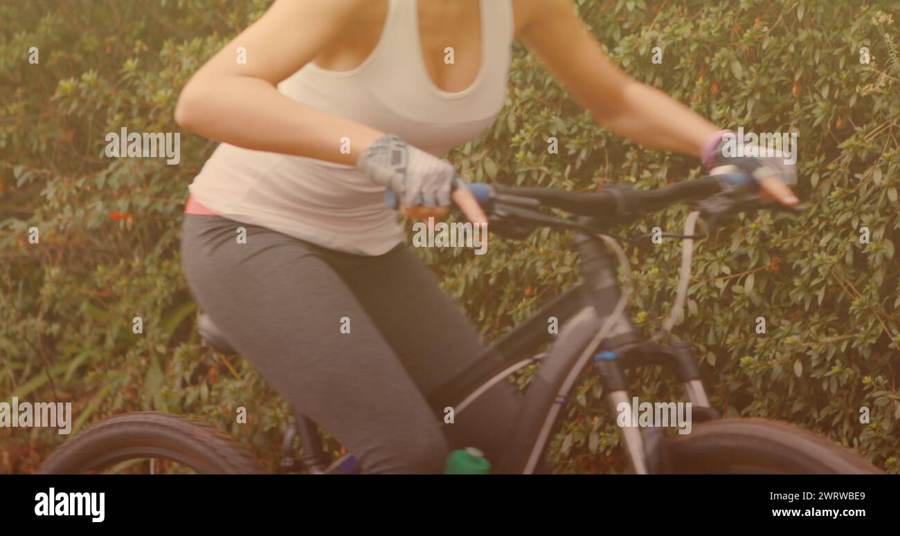 Lichtflecken gegen den mittleren Teil der Frau, die Handschuhe trägt, bevor sie mit dem Fahrrad fährt Stockfoto