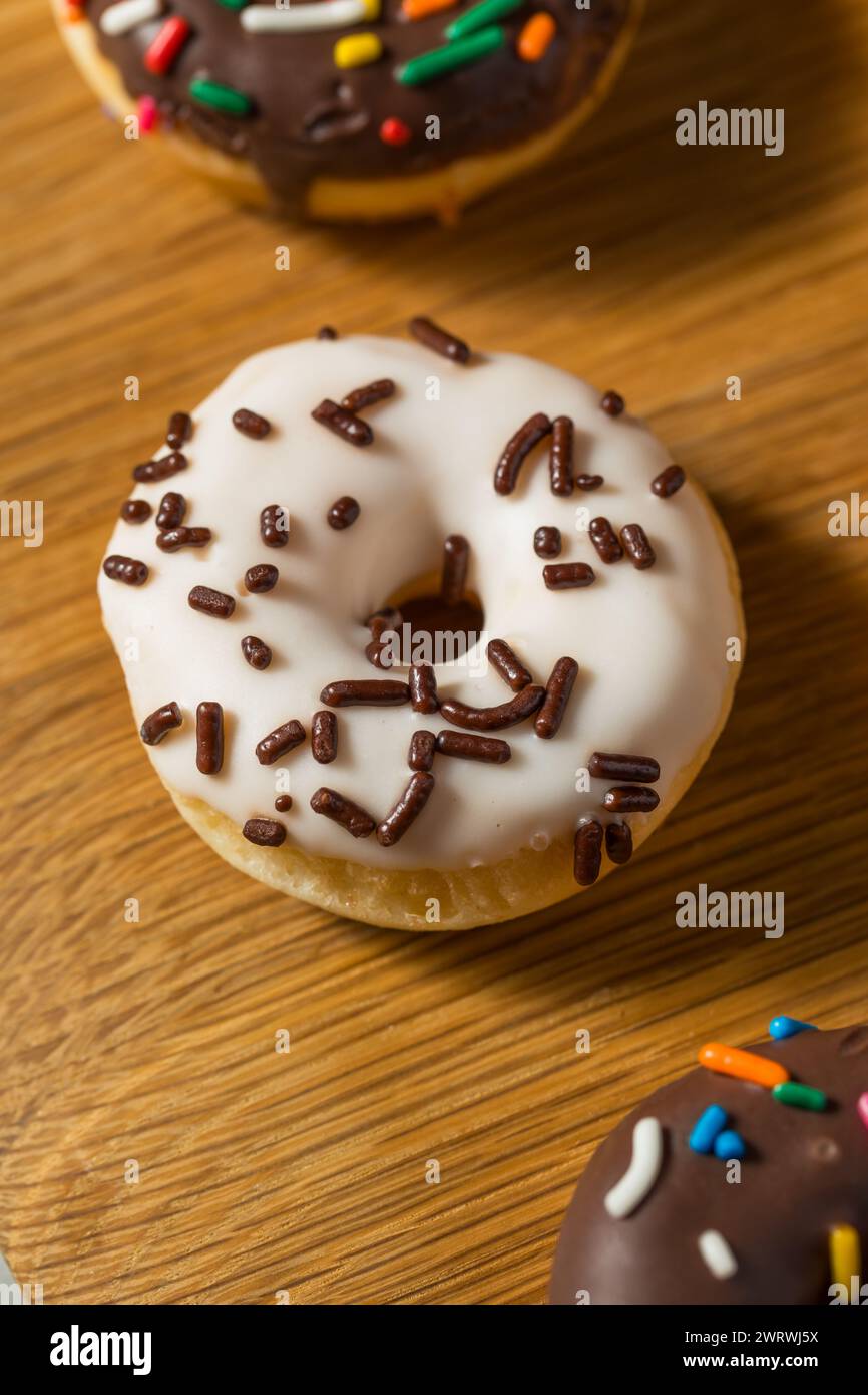 Hausgemachte kleine Mini Donuts zum Frühstück mit Sprenkeln und Zuckerguss Stockfoto