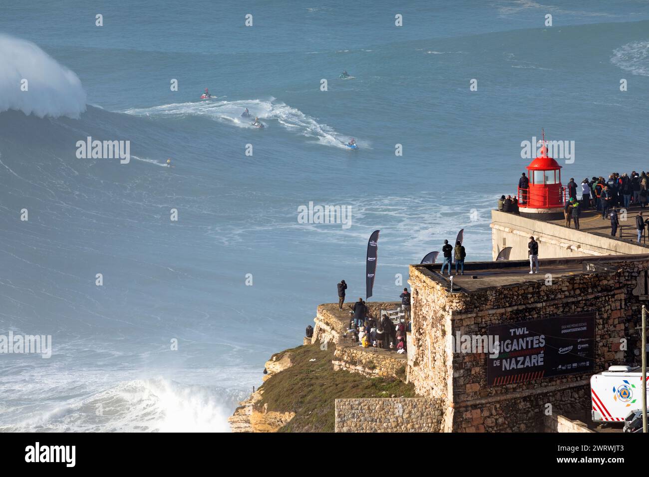 Europa, Portugal, Region Oeste, Nazaré, Surfer und Support Jet Skis auf riesigen Wellen in der Nähe von Praia do Norte während des Free Surfing Event 2022 Stockfoto