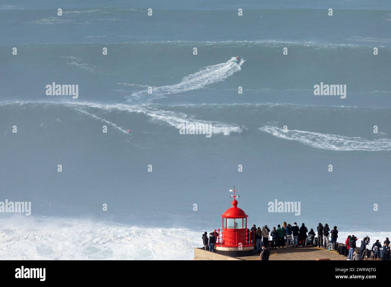 Europa, Portugal, Region Oeste, Nazaré, Surfer und Support Jet Skis auf riesigen Wellen in der Nähe von Praia do Norte während des Free Surfing Event 2022 Stockfoto
