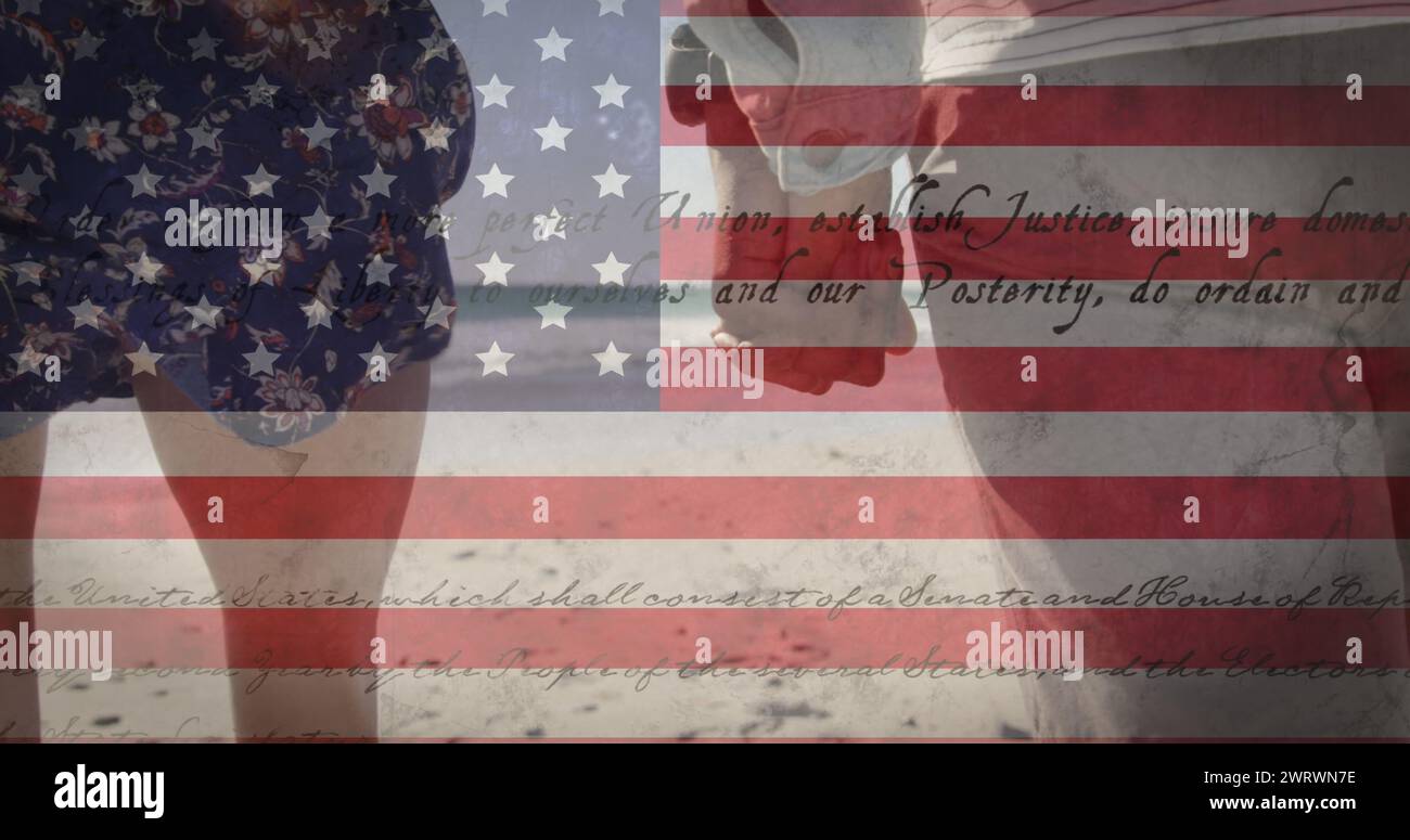 Bild der amerikanischen Flagge, die schwingt, und Konstitutionstext über zweirassigem Paar am Meer auf Sommerurlaub Stockfoto