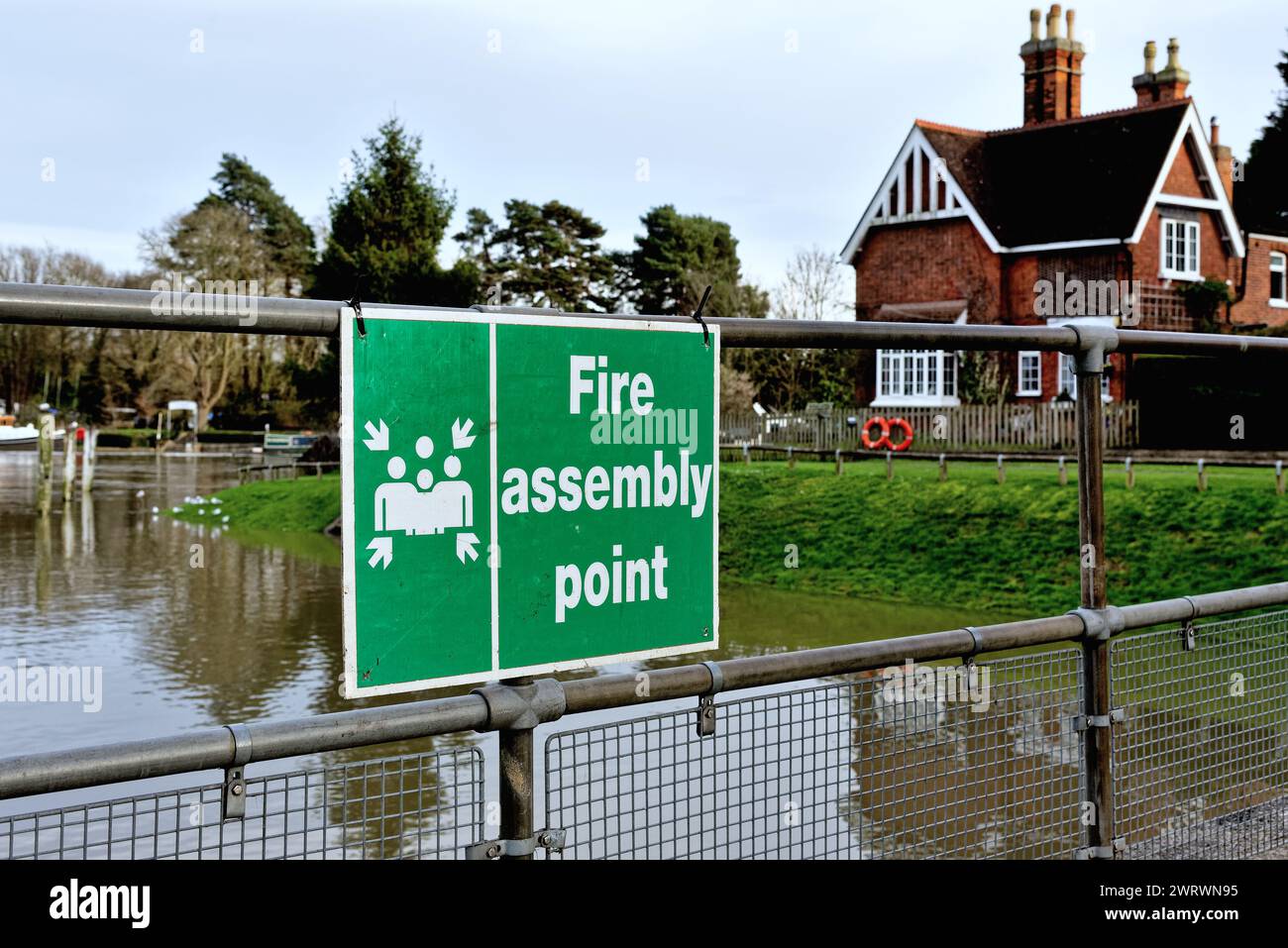 Ein Schild an den Geländern am Shepperton-Schloss mit dem Hinweis „Fire Assembly Point“ Surrey England UK Stockfoto