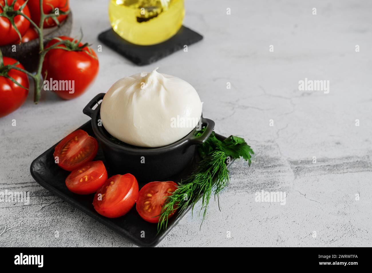 burrata mit Tomaten. Caprese-Salat mit Tomaten, Burrata und Kräutern. Weichkäse in einer Burrata-Tüte. Kopierbereich Stockfoto