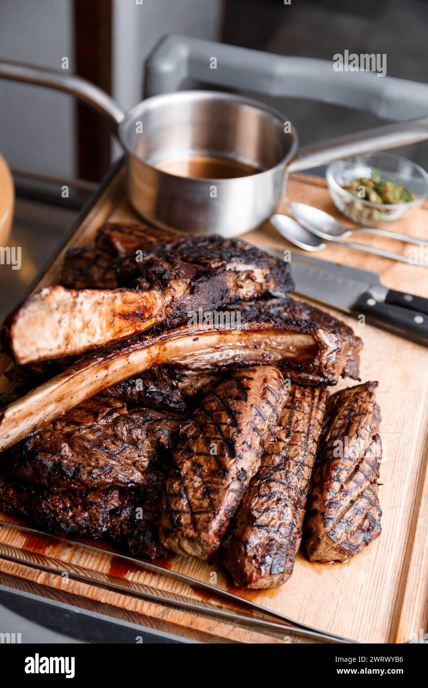 Verschiedene Arten köstlicher, saftiger gegrillter Steaks auf einem Holzbrett in einem Restaurant. Ribeye Steak, Filet auf Feuer gekocht. B-B-Q. Stockfoto