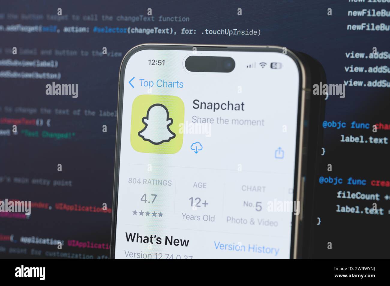 New York, USA - 23. Februar 2024: Snapchat auf dem iphone-Bildschirm mit unscharfem Code-Programmierhintergrund Stockfoto