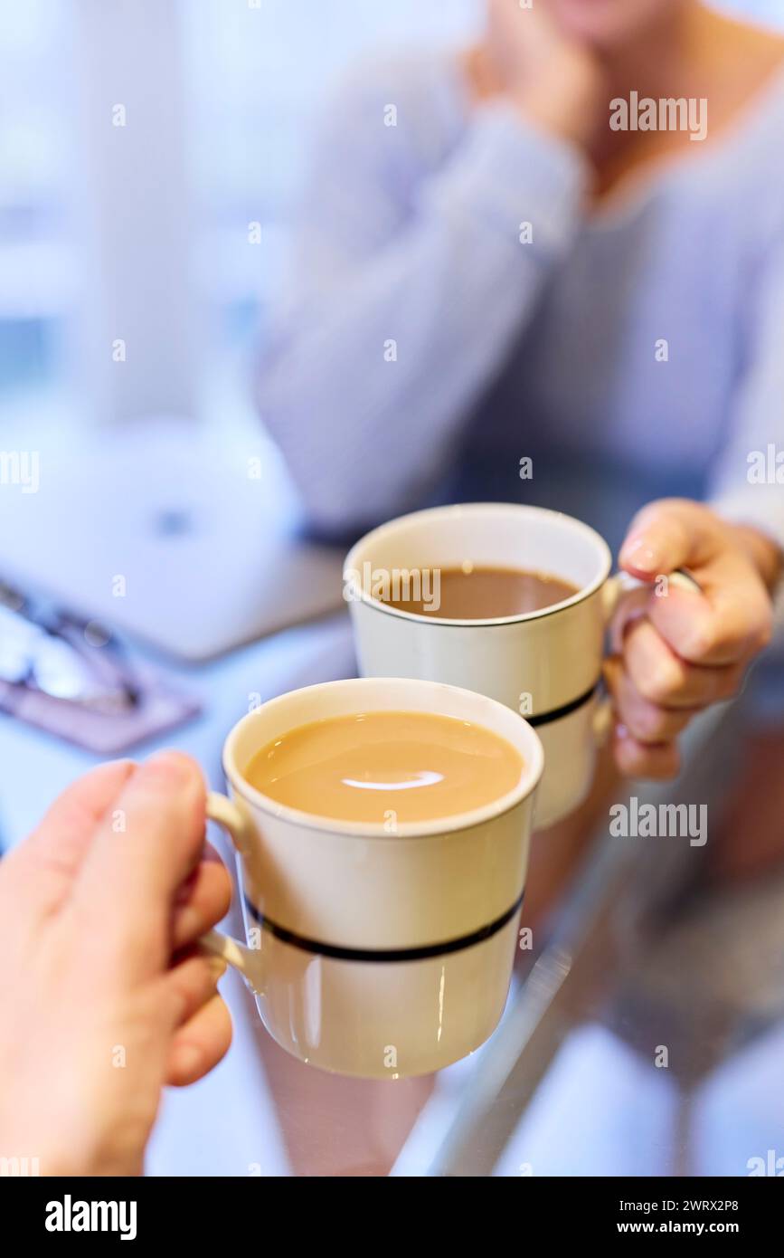 Nahaufnahme eines Paares, das zusammen Tee und Kaffee trinkt Stockfoto