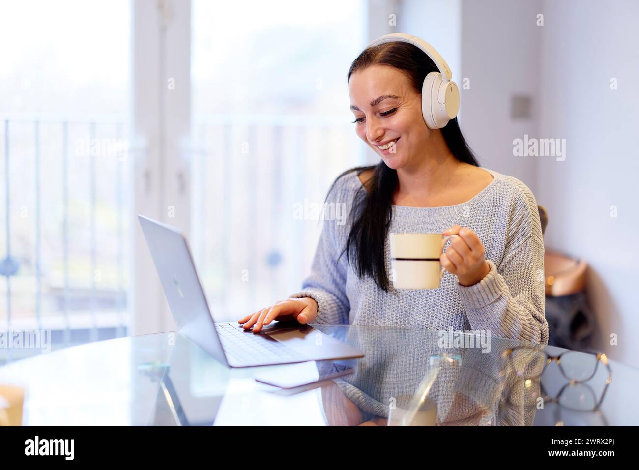 Frau anhören von Musik auf ihrem laptop Stockfoto