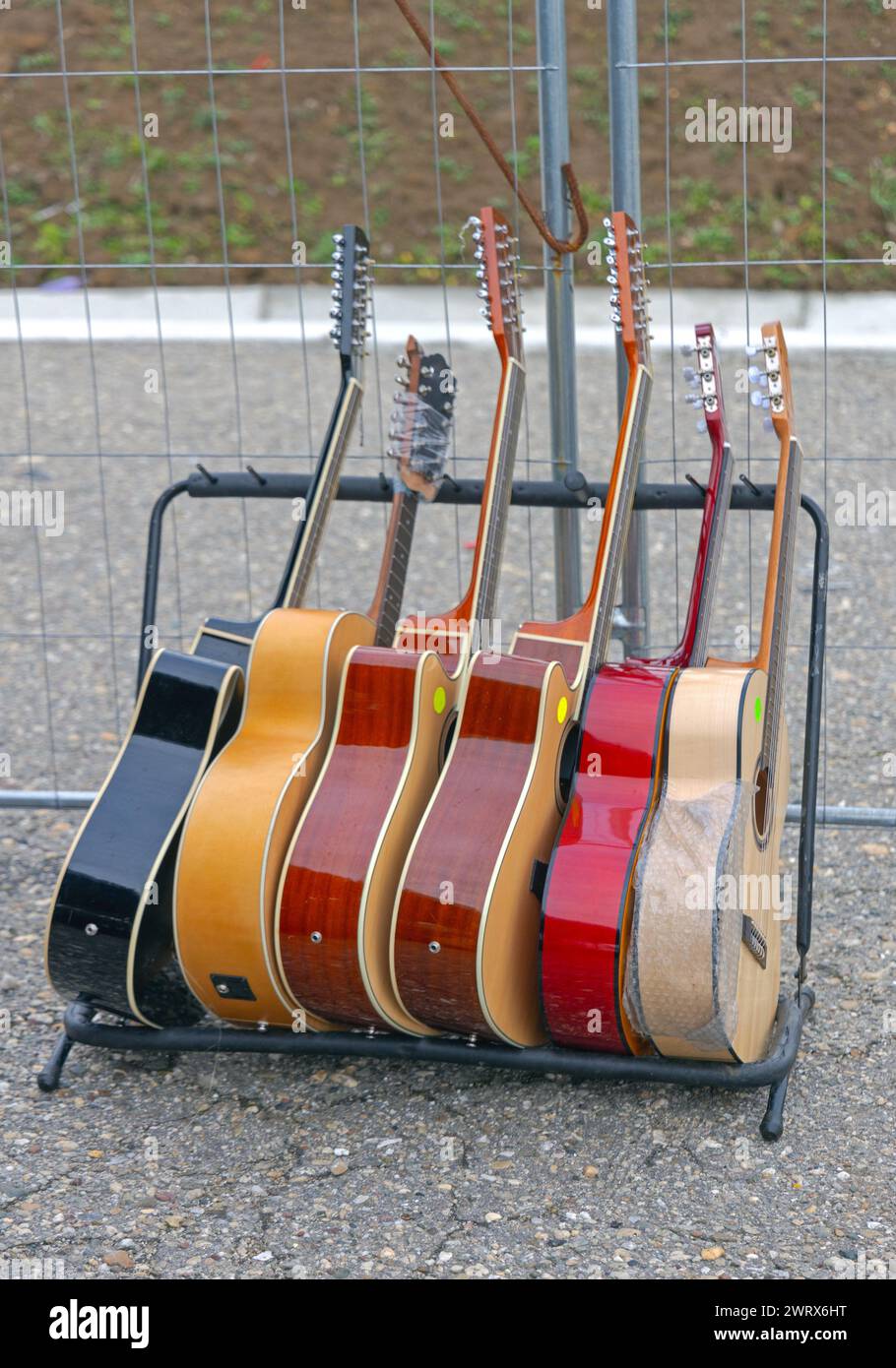 Neue Akustikgitarren im Halter zum Verkauf auf dem Straßenmarkt Stockfoto