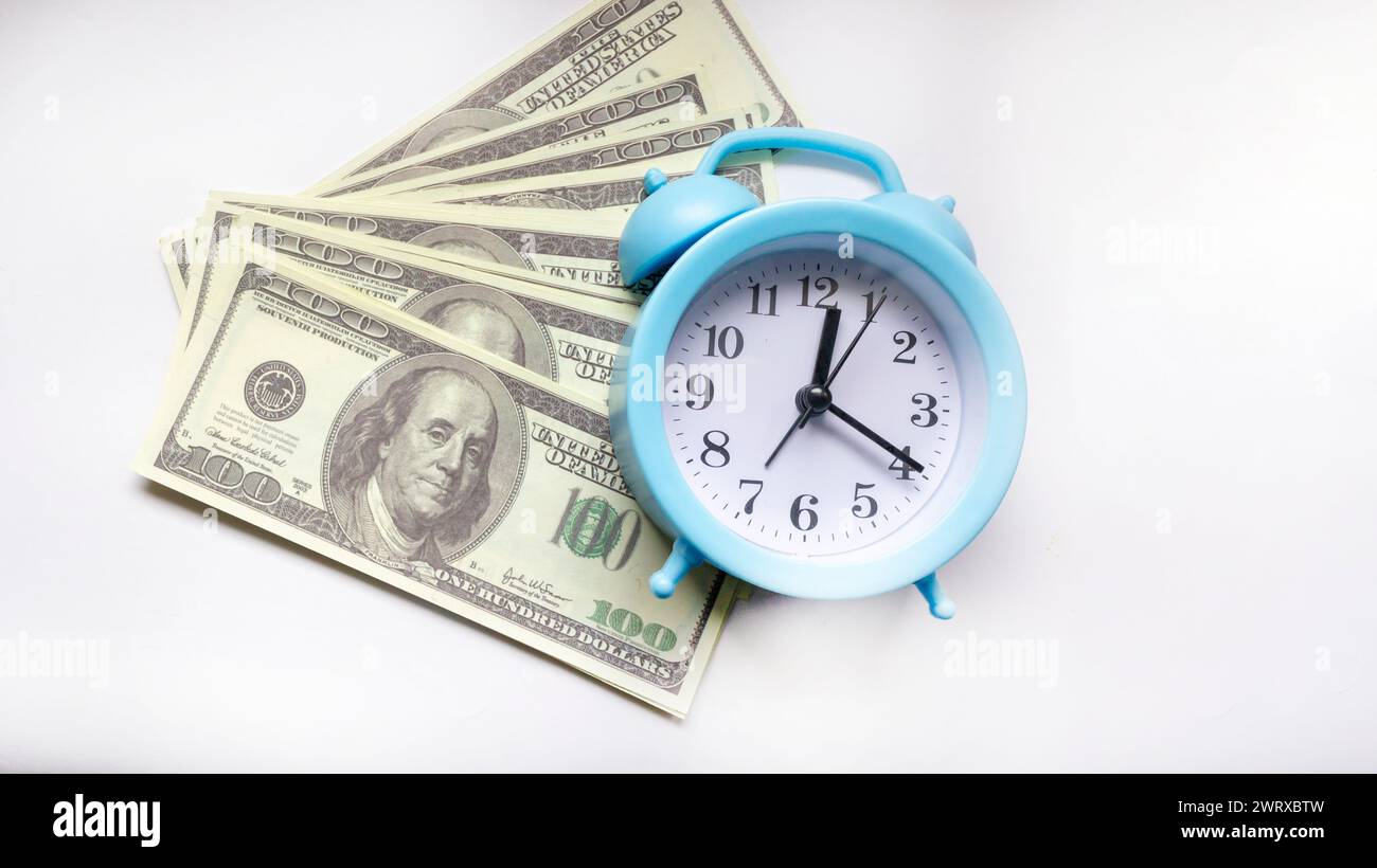 Zeit - Geld Konzept mit Uhr und Dollarscheine Nahaufnahme auf weißem Hintergrund Stockfoto