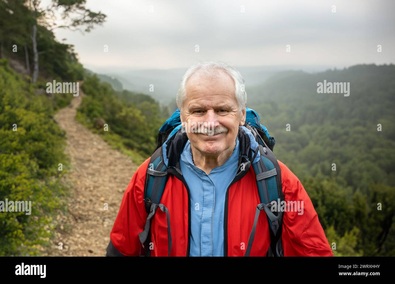 Senior Rucksacktouristen wandern allein in wunderschöner Landschaft. Symbol für die aktive Einstellung im Alter. Stockfoto