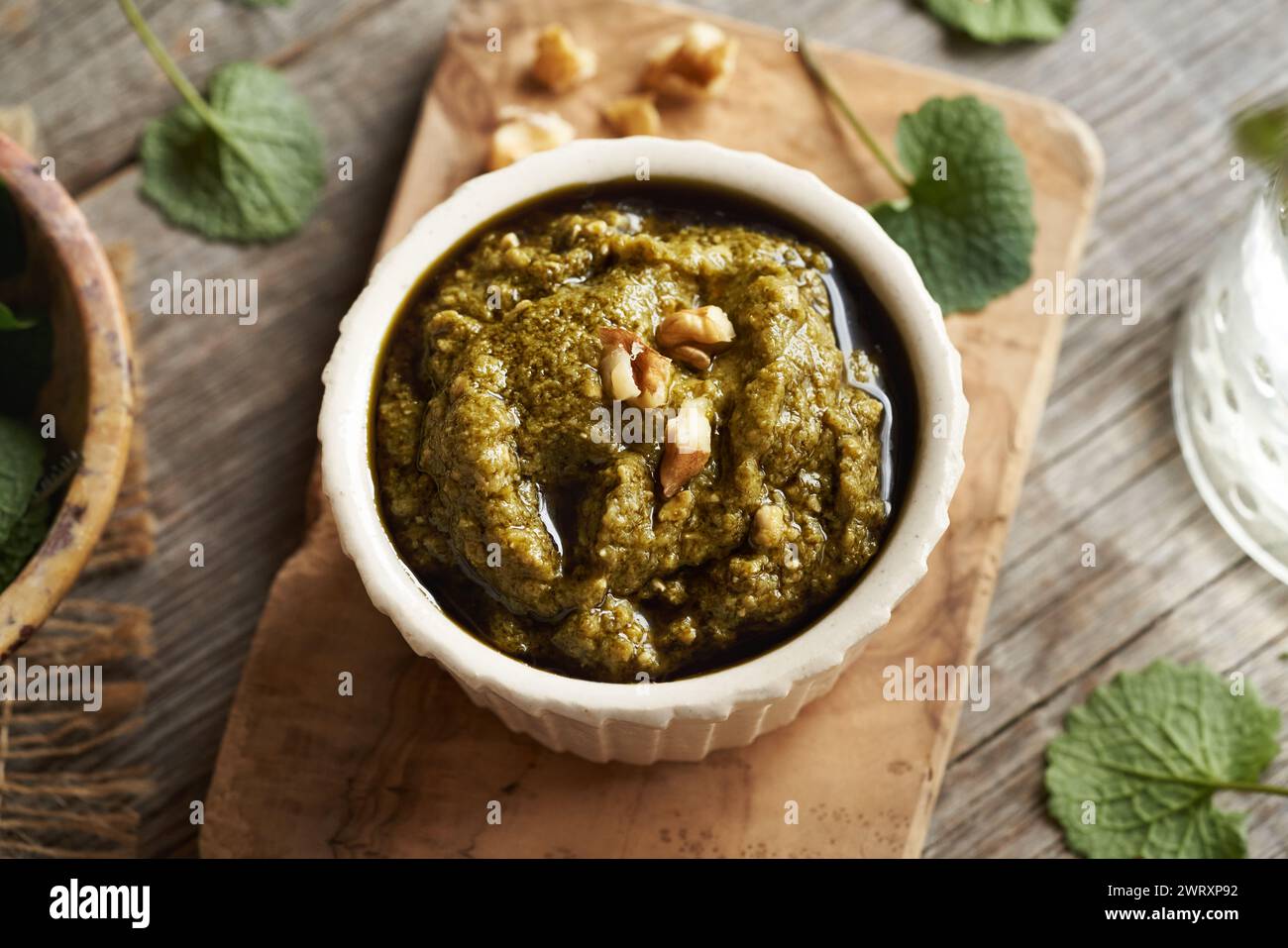 Pesto-Sauce aus frischen jungen Knoblauchsenfblättern - eine wilde essbare Pflanze, die im Frühjahr wächst Stockfoto